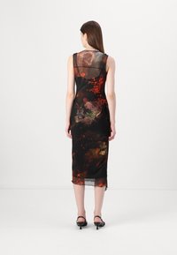 Svart transparent klänning med röda och orangea abstrakta mönster, midi-längd, figurnära silhuett och en subtil kantdetalj. Minimalistisk design, ärmlös.