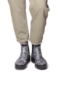 Kumipohjaiset nilkkasaappaat sinivihreässä ja harmaassa kamouflagekuviossa, joissa on teksturoitu pinta, elastiset sivupaneelit ja paksu musta pohja.