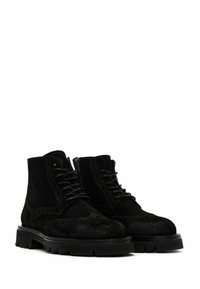 Botas de tobillo de ante negro con acentos de cuero, que cuentan con un diseño de cordones, cremallera lateral y suela resistente con profundos surcos para mayor tracción.
