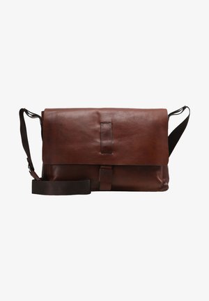 Bruin leren schoudertas met een klep die omgevouwen kan worden, een verstelbare schouderriem en een sluitband aan de voorkant voor veilige toegang.