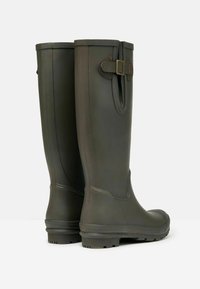 Tumed roheline kummist vihmajalanõud, millel on nõtke disain, ääristatud õmblused ja dekoratiivne krae detail ülaosas. Tekstuuritud põhi libisemisvastasuse tagamiseks.