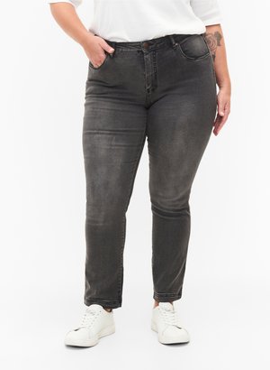 Dark gray denim jeans with a slim fit, five-pocket design, belt loops, and subtle fading. Paired with white sneakers.