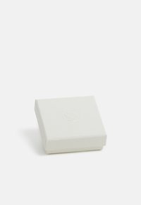 Vit, texturerad smyckeslåda med en platt rektangulär form och en subtil präglad logotyp på locket. Stängd position, minimalistisk design.