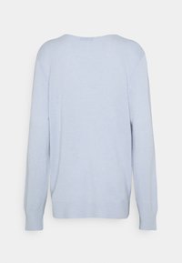 Ljusblå stickad tröja med vid halsringning, lång ärm, ribbade ärmslut och avslappnad passform. Mjuk textur, minimalistisk design.