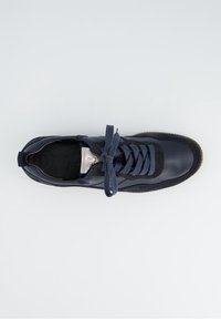 Granatowy skórzany sneaker z zamszowymi akcentami, grubymi sznurowadłami zawiązanymi na kokardę oraz brązową, rowkowaną gumową podeszwą, widziany z góry.