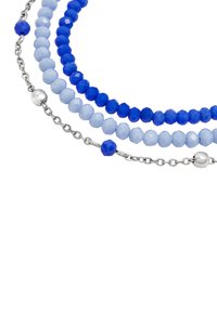 Tre strängar med pärlsmycken som har ljusblå och mörkblå fasetterade pärlor, insprängda med silverhardware och accenter.