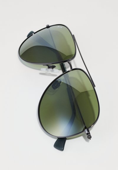 Black metal aviator sunglasses with green gradient lenses, featuring a double bridge, nose pads, and curved temple ends for comfort.