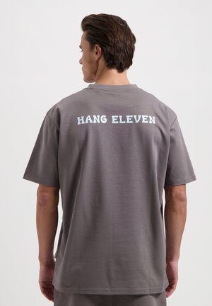 Gray cotton T-shirt with a relaxed fit, featuring a light blue "HANG ELEVEN" text printed on the back. Simple, short sleeves, and a crew neck.