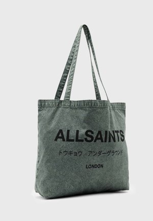 Grå stof-tote-taske med lange håndtag, "ALLSAINTS" trykt med store sorte bogstaver, japanske tegn nedenunder og "LONDON" nederst.