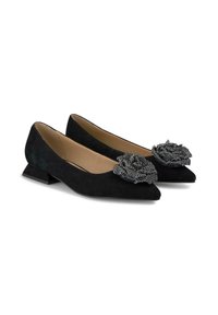 Chaussures plates en suede noir avec un bout pointu et un petit talon, ornées d'un accent floral en perles décoratives sur le devant.