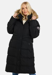 Sort puffy parka med falsk pelskant på hætten, frontlukning med trykknapper, sidelommer med lynlås og quiltet struktur.