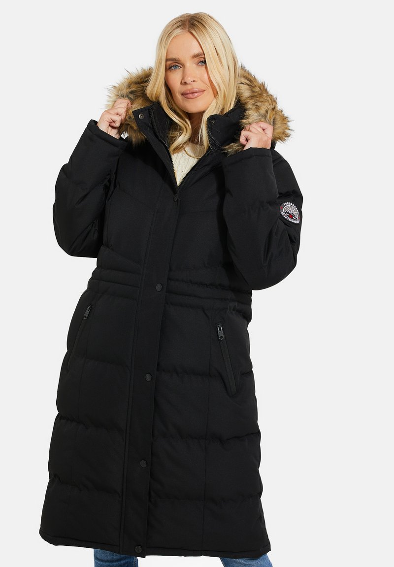 Sort puffy parka med falsk pelskant på hætten, frontlukning med trykknapper, sidelommer med lynlås og quiltet struktur.