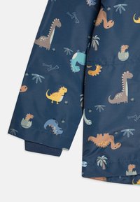 Sateen merinegeri berwarna biru laut dengan grafik dinosaurus dan tumbuhan. Dilengkapi dengan manset elastis dan bahan yang halus serta tahan air.