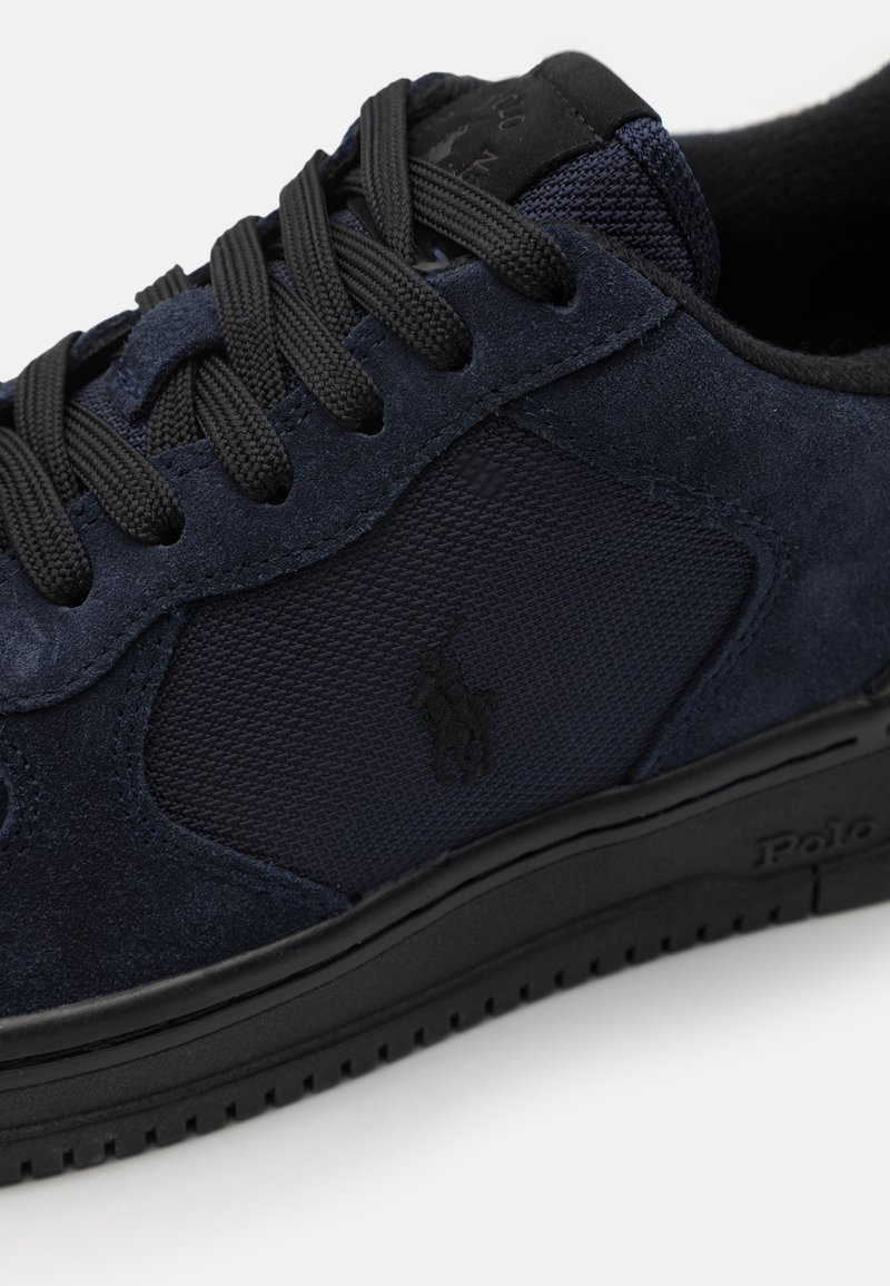 Granatowe zamszowe sneakersy z siateczkowym panelem, płaskimi czarnymi sznurowadłami i wytłoczonym logo. Gruba czarna gumowa podeszwa z teksturowanym gripem.