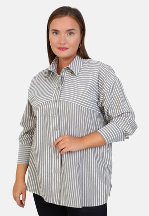 Camisa de botones a rayas grises y blancas con cuello puntiagudo, mangas largas y detalle de bolsillo frontal. Textura de tela suave y tejida.