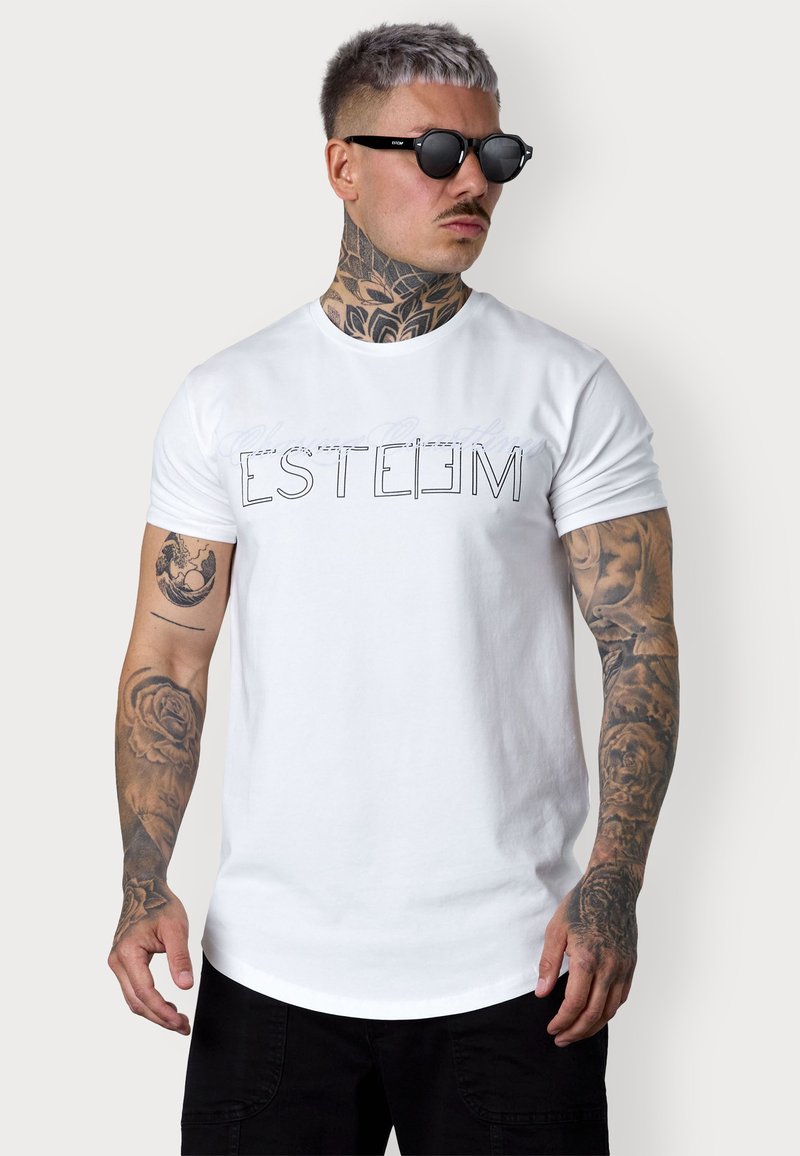 Weißes Baumwoll-T-Shirt mit kurzen Ärmeln, das einen auffälligen schwarzen Aufdruck des Wortes "ESTEEM" zeigt. Das Modell trägt außerdem schwarze Sonnenbrillen.