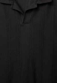 Pullover nero con un design testurizzato a righe verticali. Il tessuto presenta motivi in maglia e uno stile colletto classico.