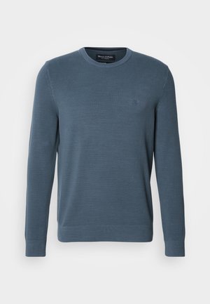 Maglione azzurro lavorato a maglia con maniche lunghe, scollatura rotonda, motivo a rilievo, polsini a coste e un emblema sul petto.