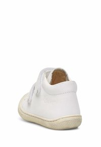 Scarpa in pelle bianca con una texture morbida, forma arrotondata e suola in gomma. Presenta un design a caviglia bassa e cuciture a vista per i dettagli.