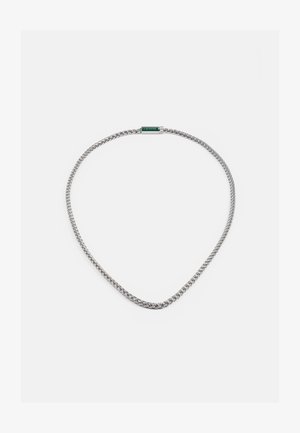 Silver kedja halsband med en vriden design, med en grön accent vid låset. Slät textur med ett flexibelt, lätt utseende.