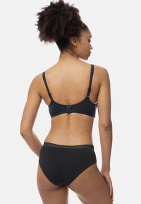 Czarny bawełniany biustonosz z regulowanymi ramiączkami i zapięciem na hak, połączony z pasującymi czarnymi majtkami typu high-waist z teksturowanym pasem.