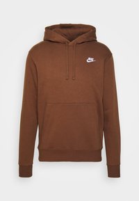 Hnědá mikina Nike s klokaní kapsou, kapucí na šňůrku a bílým logem na levém prsu. Vyrobena z měkké l�átky. Dlouhé rukávy s žebrovanými manžetami.