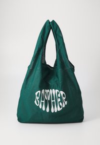 Grüne Netztragetasche mit zwei runden Griffen, auf der Vorderseite mit dem Text "BATHER" in weißer, fetter, verspielter Schrift.