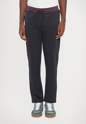 Navy sweatpants with a ribbed waistband featuring a drawstring. Zip side pockets and a tapered leg design. Soft fabric with smooth texture.