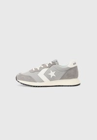Sive usnjeni tenis z belim gumijastim podplatom. Ima zvezdasti poudarek, kontrastni stranski logo in bele vezalke. Klasičen atletski dizajn.