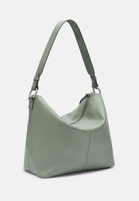 Torba hobo w miękkiej zielonej skórze, z luźnym kształtem, zamknięciem na zamek błyskawiczny oraz odpinanym, regulowanym paskiem. Widoczne są detale szwów.