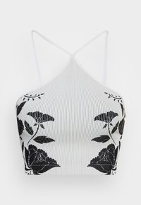 Top cropped canelado branco com padrões florais pretos, com alças finas e design de pescoço halter. Textura suave com acentos contrastantes.