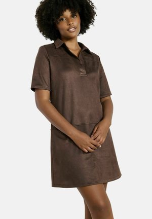 Abito polo corto marrone con maniche corte, realizzato in tessuto morbido e testurizzato, dotato di colletto e una vestibilità leggermente ampia, che arriva a metà coscia.
