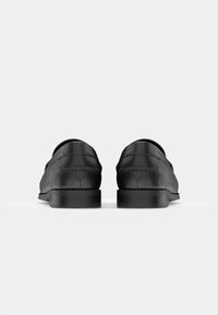 Schwarze Lederschuhe mit glatter Oberfläche, runder Zehenpartie und minimaler Naht. Niedriger Absatz und schlichtes Design ohne Verzierungen.