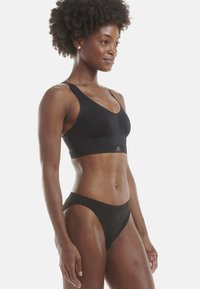 Černá sportovní podprsenka a bikini set z hladkého materiálu. Podprsenka má široká ramínka, výstřih do véčka a decentní branding. Celkově přiléhavý design.