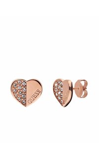 Boucles d'oreilles en forme de cœur en or rose avec des embellissements en cristal et une finition polie. Présente la gravure "GUESS" sur un côté.