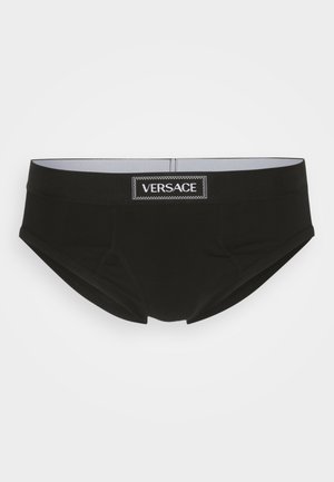 Boxers noirs avec une coupe ajustée, une ceinture élastique et une étiquette du logo Versace bien visible en blanc. Texture de tissu lisse sans motifs.