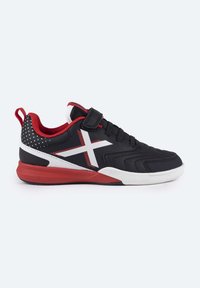 Zapatillas deportivas negras con acentos rojos, suela blanca y cinta de velcro. Presentan un patrón de estrellas en el talón y un diseño geométrico en la parte superior.