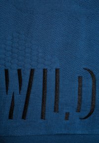 Maglione lavorato a maglia blu con un motivo testurizzato e la parola "WILD" in grassetto nero, caratterizzato da una texture liscia e morbida.