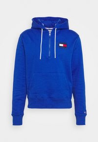 Blå hoodie i bomullsblandning med halvdragkedja, framficka och en liten broderad logga på vänster bröst.