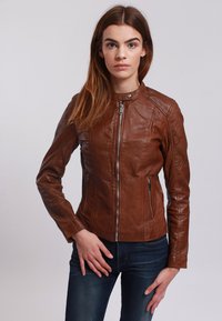 Giubbotto in pelle marrone con un design aderente, colletto alto e zip asimmetrica. Presenta due tasche anteriori con zip e una texture liscia.