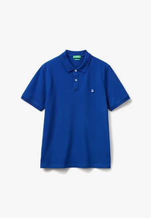 Camisa polo azul de manga corta con dos botones blancos y pequeño logotipo bordado en blanco a la izquierda del pecho, presentada sobre fondo blanco.