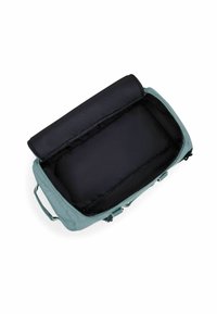 Sac de sport en tissu bleu clair avec un intérieur spacieux noir, fermeture zippée, et un panneau supérieur texturé noir. Dispose de poignées de transport doubles.