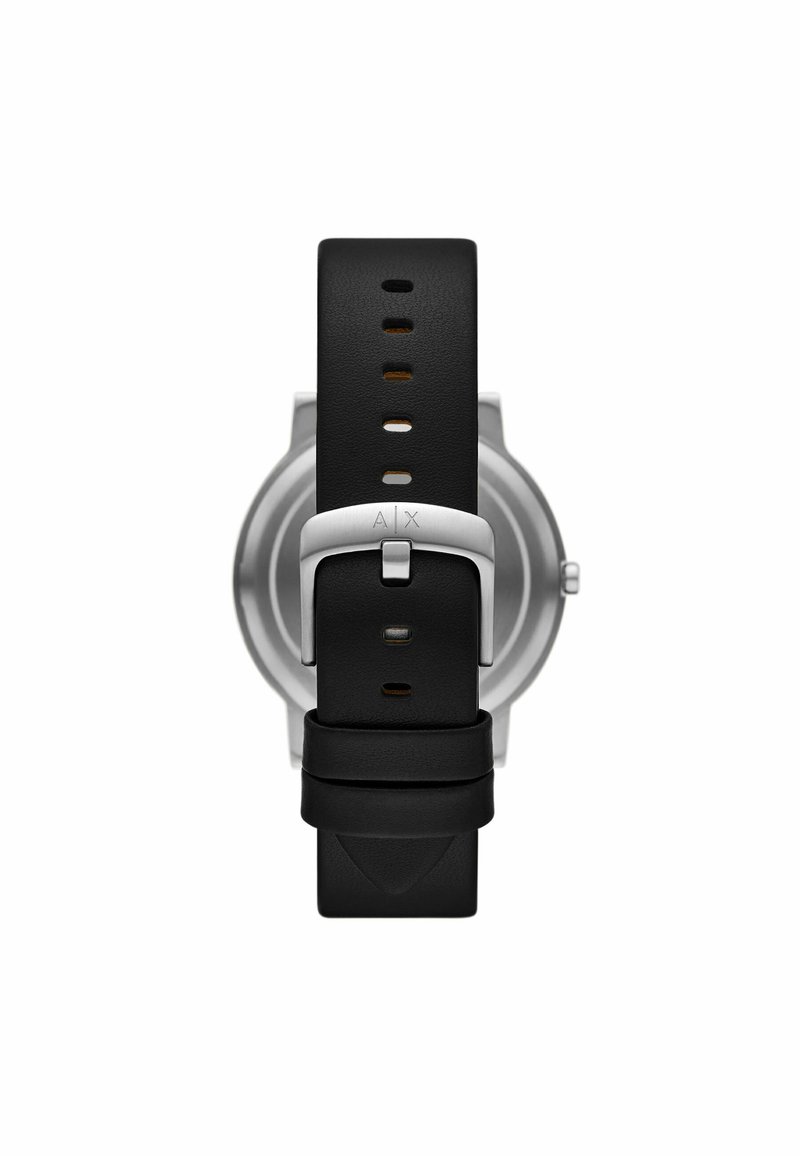Correa de reloj de goma negra con hebilla de acero inoxidable plateado, que cuenta con múltiples agujeros de ajuste y el logo de la marca grabado en el herraje.
