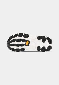 Black and white rugged sole with textured rubber treads, featuring a prominent Vibram logo and a mix of angular and rounded shapes.