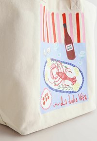 Kapsička z plátna v smotanovej farbe s maľbou homára, pruhovanými červenými a ružovými akcentmi a etiketou na fľaši vína s nápisom "dobré VÍNO."