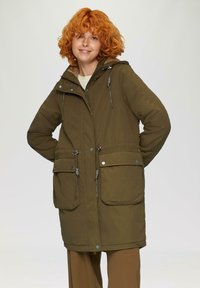 Maslinasto zeleni parka jakna s kapulja�čom na šnure, dva velika prednja džepa i zatvaranjem na patent. Sadrži srebrne dijelove i podesive četvorke.