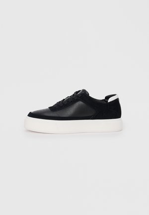 Sneaker nera con pannelli in pelle liscia e suede, lacci piatti, punta arrotondata e suola in gomma bianca. Logo distintivo sul tallone.
