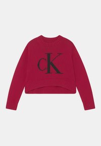 Červený krátký svetr s žebrovaným výstřihem a manžetami, na přední straně s velkým černým logem "ck". Měkká pletená textura.