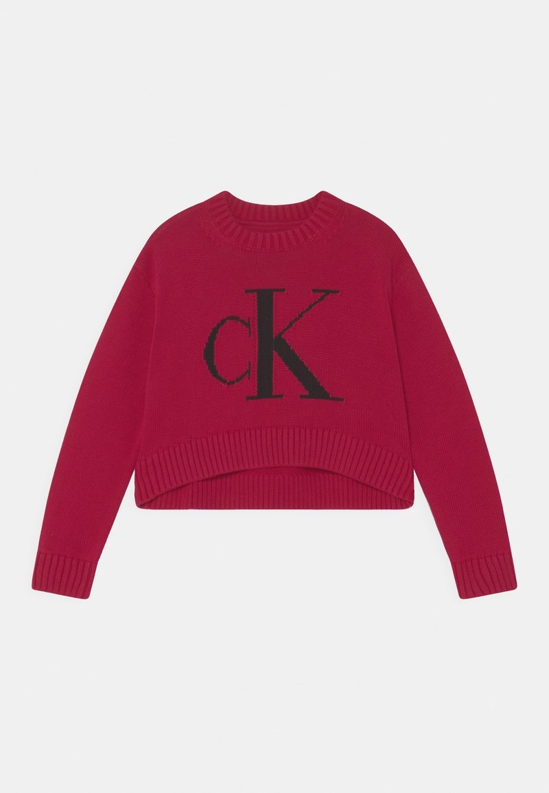 Červený krátký svetr s žebrovaným výstřihem a manžetami, na přední straně s velkým černým logem "ck". Měkká pletená textura.