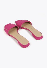 Ružové slip-on sandále s detailmi z pletenej pásky, štvorcovou špičkou a plochou podrážkou. Interiér je béžový s jemným brandingom.